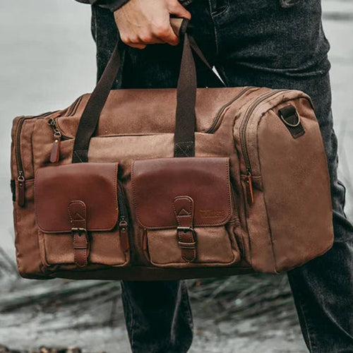 Desert colored canvas duffle bag for men, outdoor background, rugged but elegant