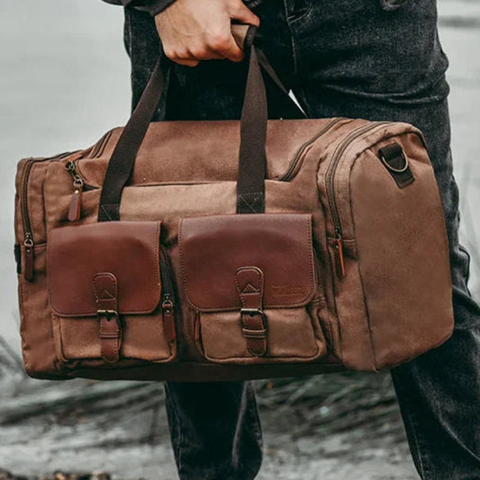 Desert colored canvas duffle bag for men, outdoor background, rugged but elegant