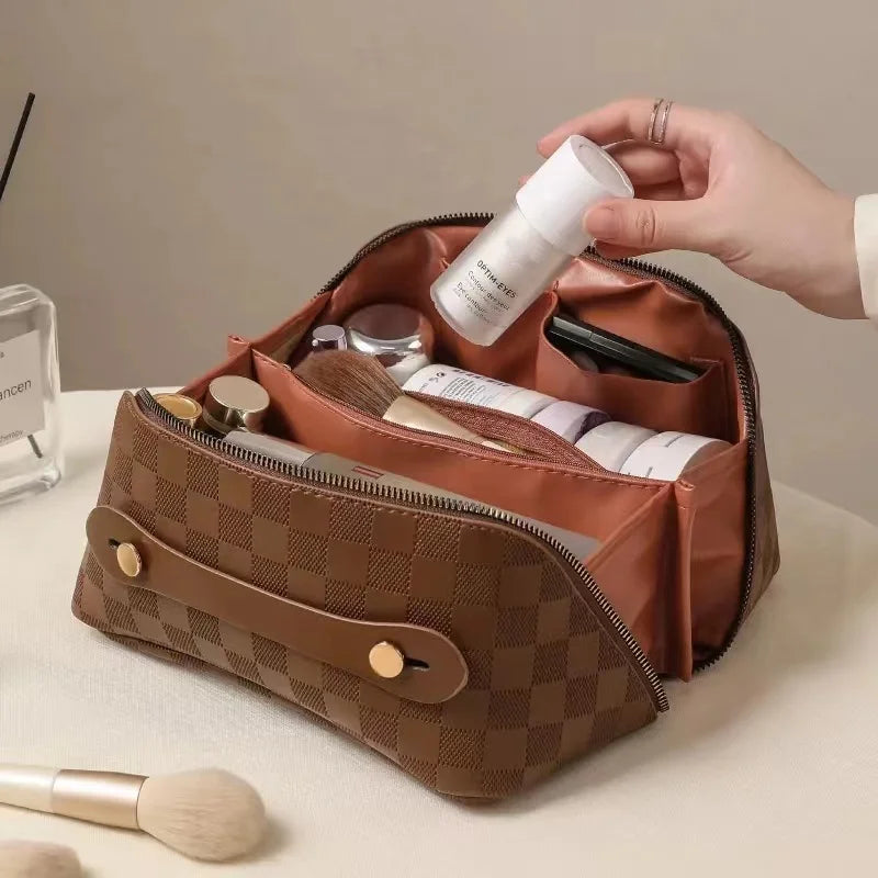 Brown toiletry bag for women, Fancy material and look, Metal zipper, Top view, Handle, Women's' hand using it, Opened toiletry bag, Filled with quality makeup, Bag sitting on table, Lifestyle image