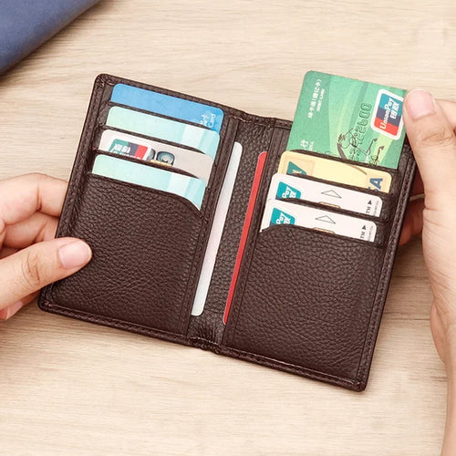 Dark Brown Leather Wallet, Filled with 8 Cards, Held by Two Hands, Light Wooden Background